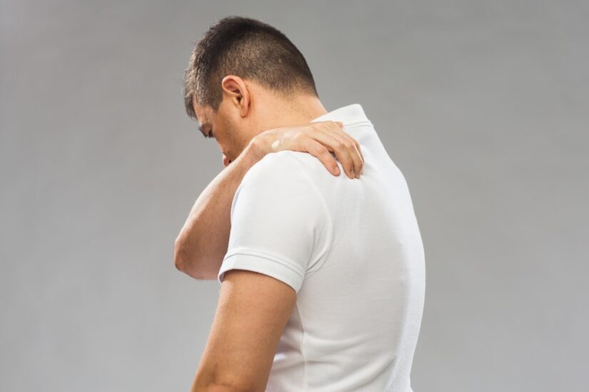 Man holding his upper back in pain